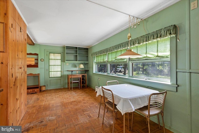 dining area featuring parquet floors, a healthy amount of sunlight, and crown molding