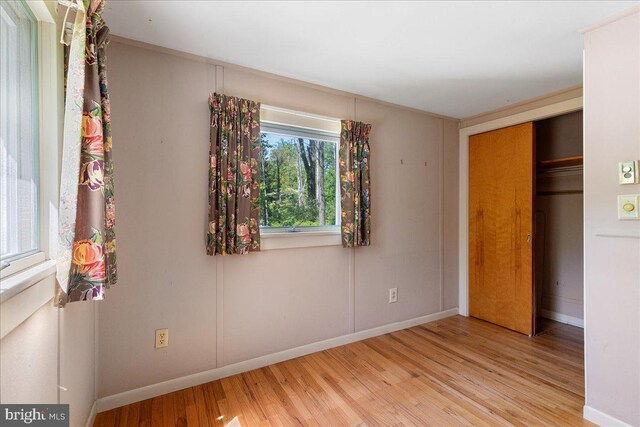 unfurnished bedroom with light wood-type flooring and a closet