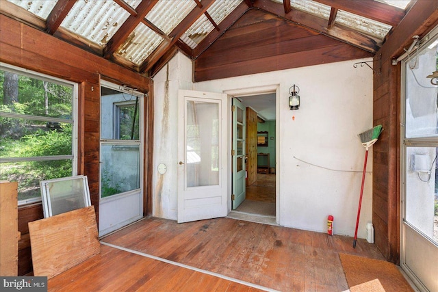 unfurnished sunroom featuring vaulted ceiling with beams