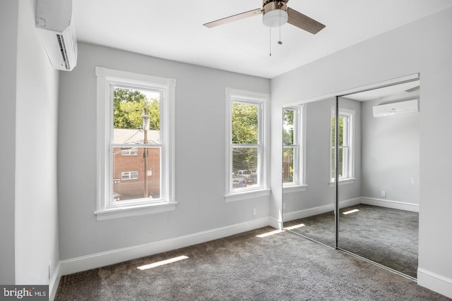 unfurnished bedroom with multiple windows, ceiling fan, a closet, and a wall mounted air conditioner