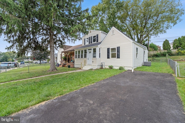 view of front facade featuring central AC and a front yard