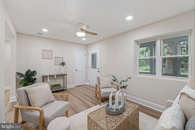 living room with light hardwood / wood-style floors and ceiling fan