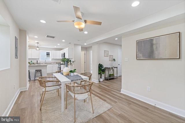 dining room with light hardwood / wood-style flooring and ceiling fan