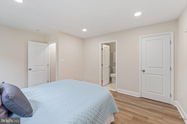 bedroom with ensuite bathroom and light hardwood / wood-style floors