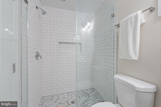 bathroom featuring toilet and an enclosed shower