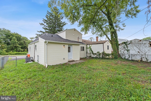 rear view of house with a lawn and central AC