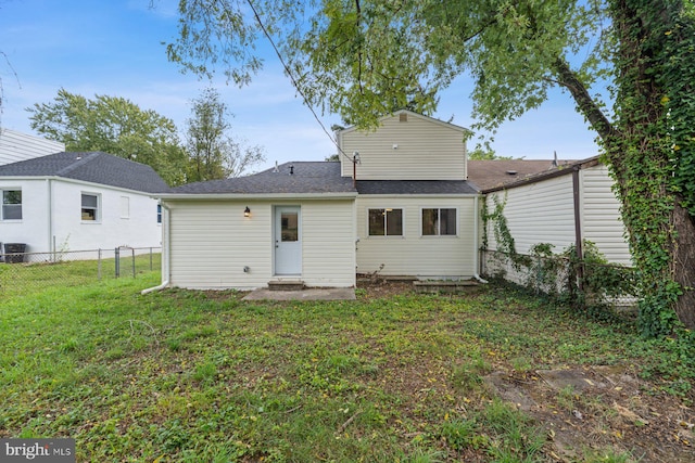 back of house featuring a lawn