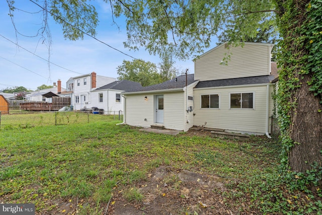 rear view of property featuring a yard