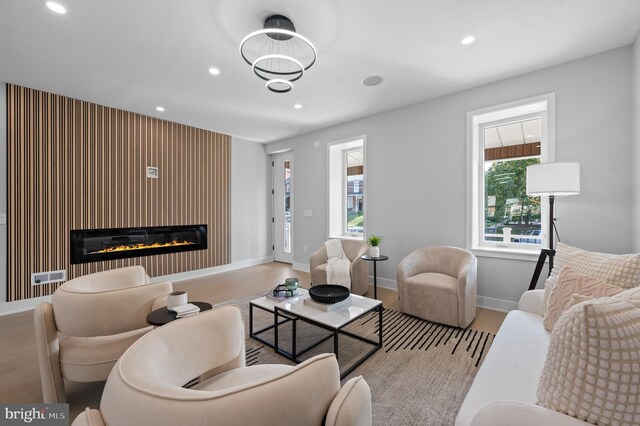 living room featuring a large fireplace and light hardwood / wood-style flooring