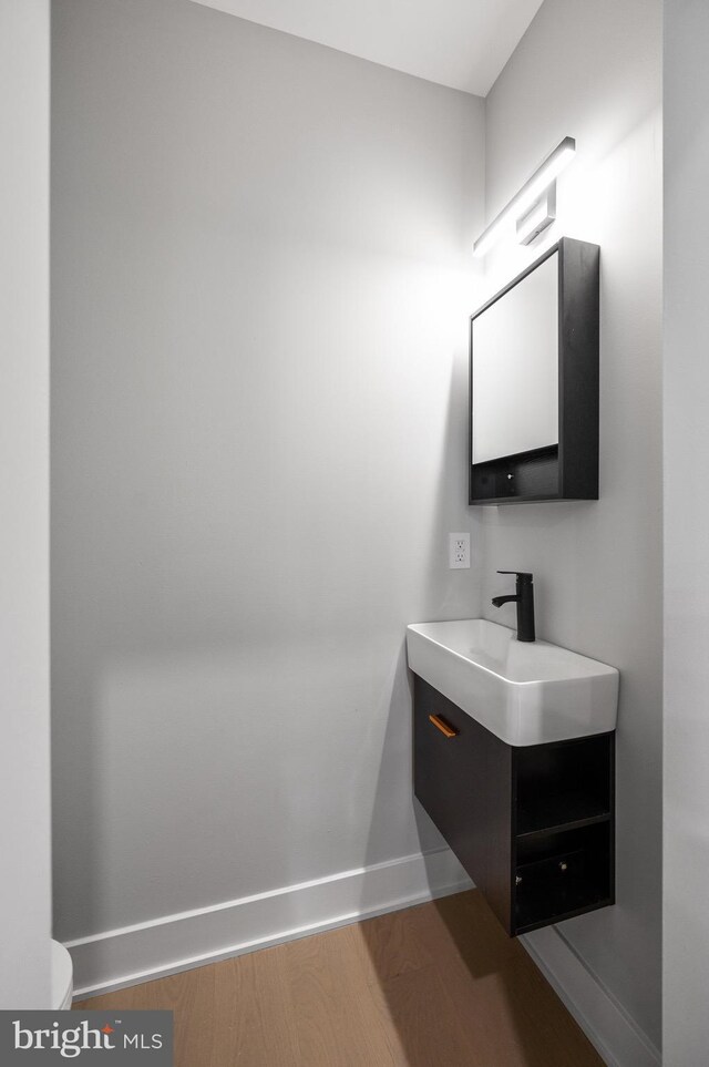 bathroom with toilet, hardwood / wood-style flooring, and vanity