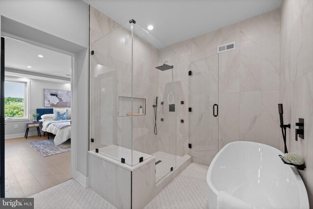 bathroom featuring separate shower and tub and hardwood / wood-style flooring