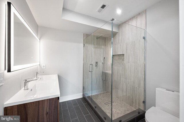 bathroom with vanity, toilet, and an enclosed shower