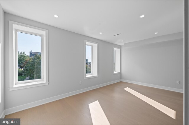 empty room featuring plenty of natural light and hardwood / wood-style floors