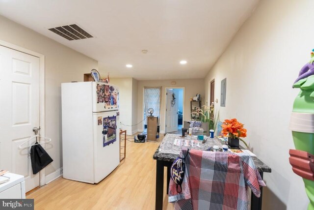 kitchen with white refrigerator and light hardwood / wood-style floors