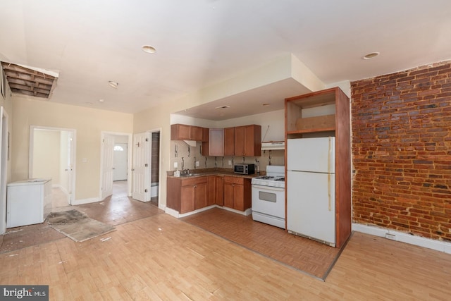 kitchen featuring light wood-type flooring, white appliances, brick wall, and sink