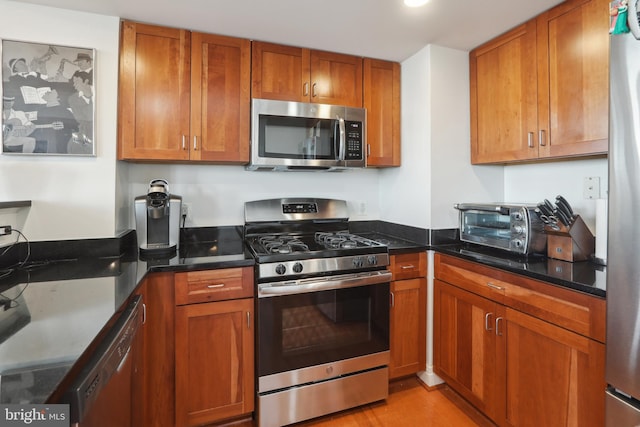 kitchen with stainless steel appliances and dark stone countertops