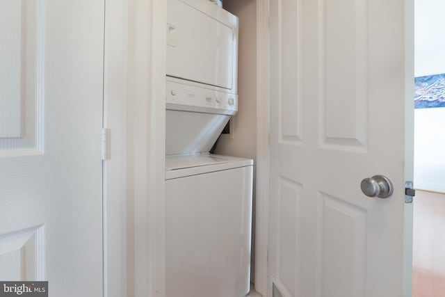 washroom featuring stacked washing maching and dryer