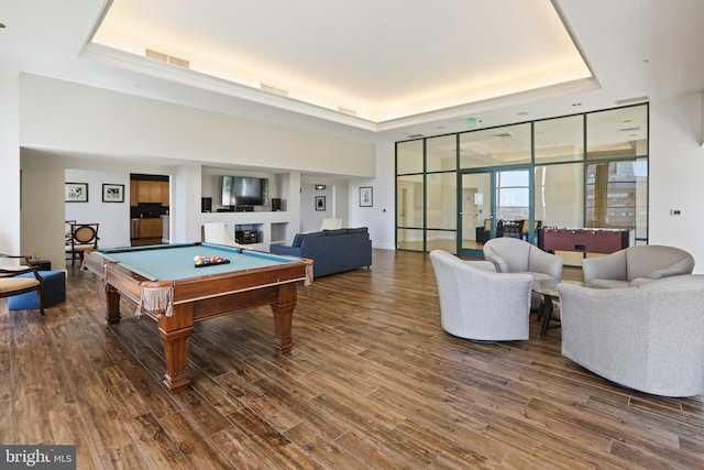 game room with a fireplace, floor to ceiling windows, pool table, wood-type flooring, and a raised ceiling