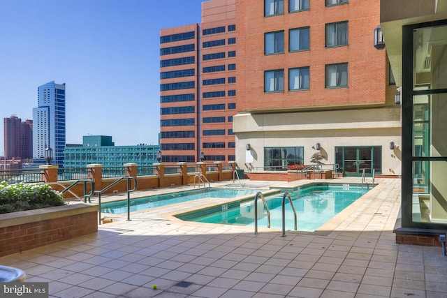 view of pool with a hot tub and a patio