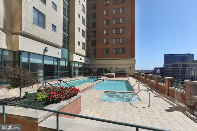 view of swimming pool with a community hot tub and a patio area