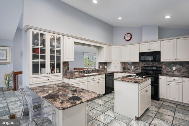 kitchen featuring white cabinets, black appliances, a center island, and sink