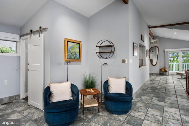 sitting room with lofted ceiling with beams and a barn door