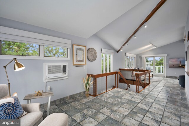 living room with vaulted ceiling with beams and a wall unit AC