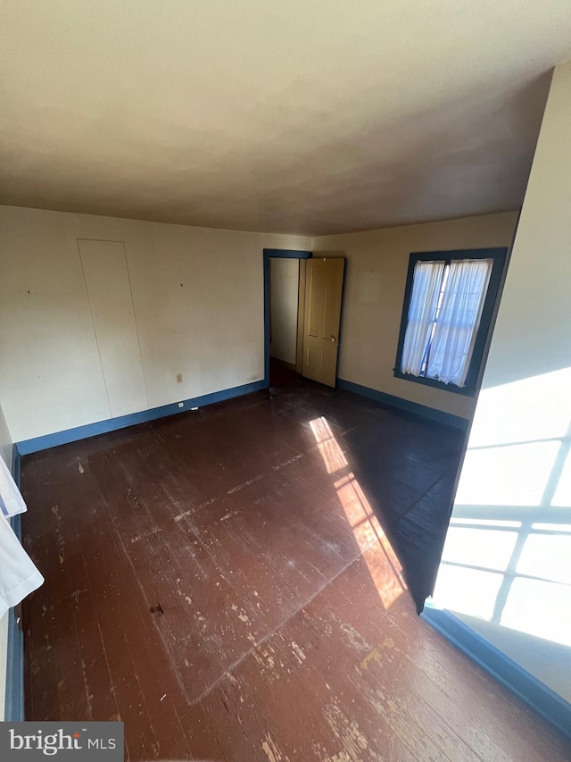 unfurnished bedroom with dark wood-type flooring