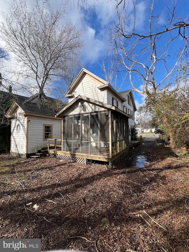 rear view of house featuring a sunroom