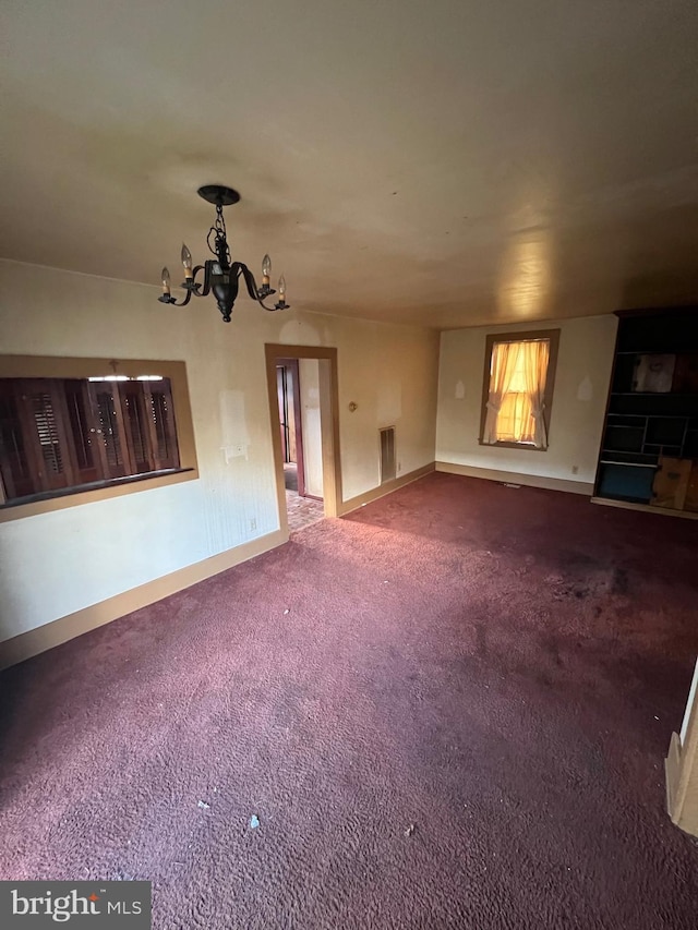 unfurnished living room featuring carpet and a notable chandelier