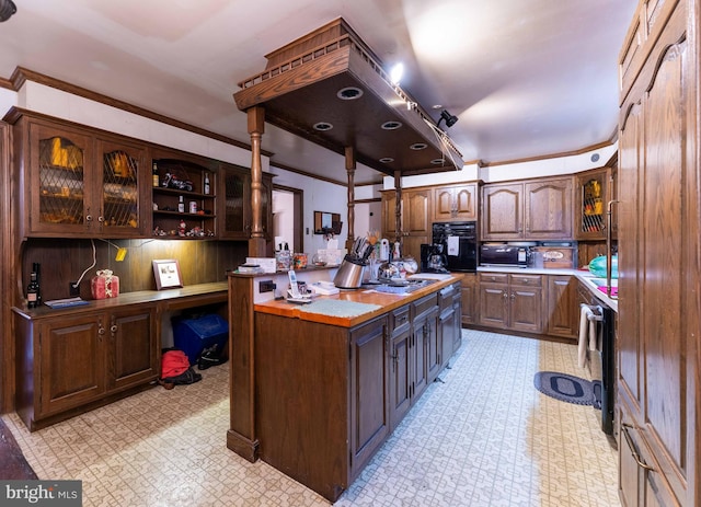 kitchen featuring crown molding, a center island, dark brown cabinets, and black oven