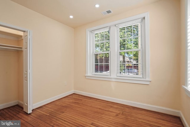 unfurnished bedroom featuring hardwood / wood-style floors and a closet