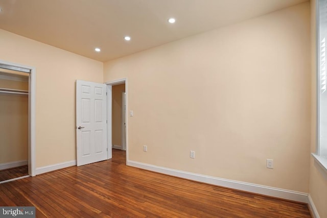 unfurnished bedroom with wood-type flooring and a closet