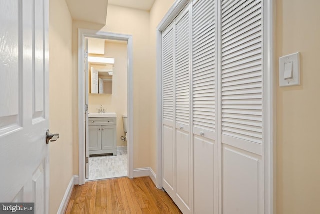 hallway featuring sink and light wood-type flooring