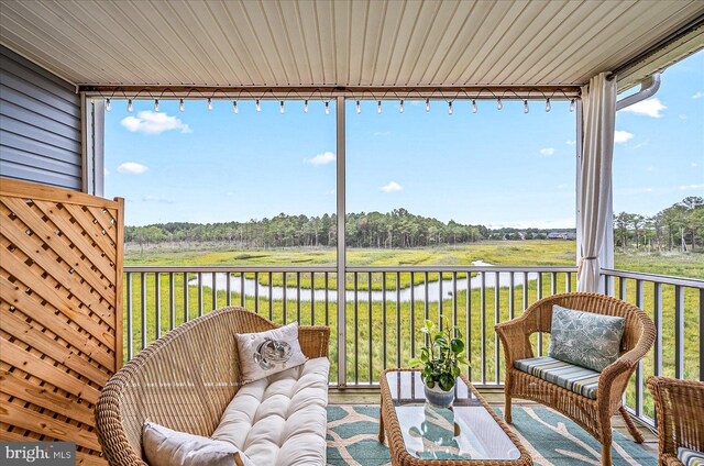 unfurnished sunroom featuring a water view and track lighting