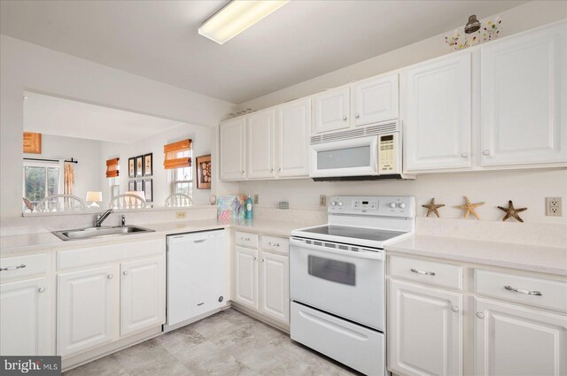 kitchen featuring white appliances, sink, and white cabinets