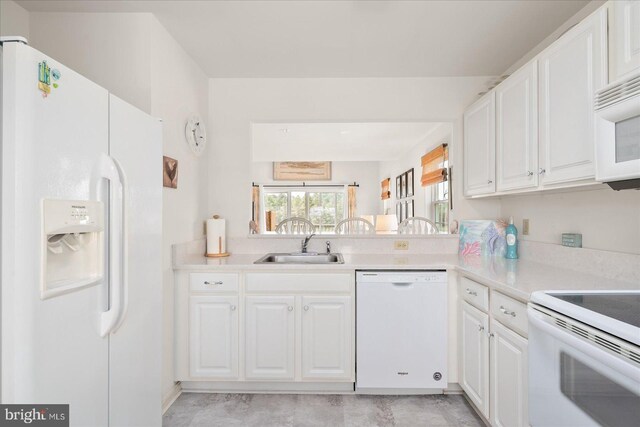 kitchen with sink, white appliances, and white cabinetry