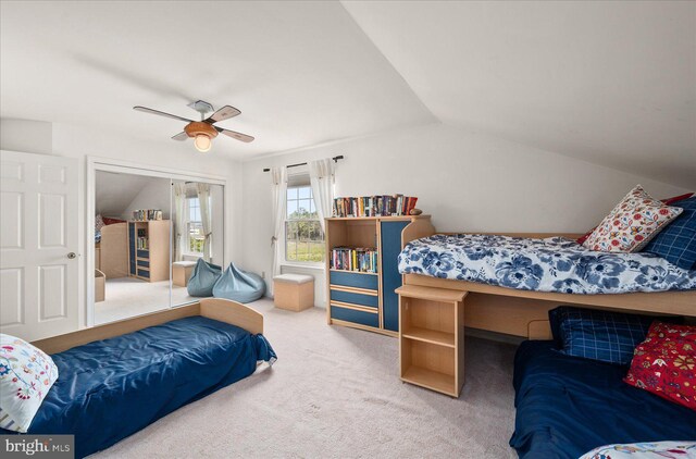 bedroom with lofted ceiling, ceiling fan, a closet, and carpet floors