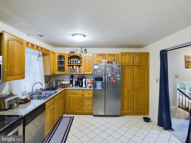 kitchen featuring light tile patterned floors, sink, backsplash, appliances with stainless steel finishes, and light stone countertops