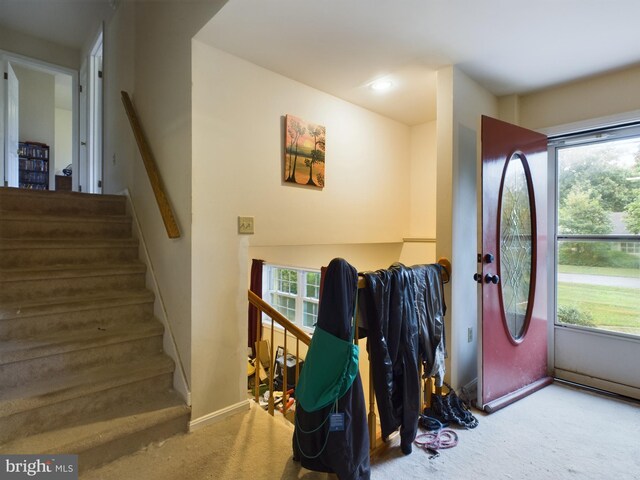 carpeted foyer entrance featuring stairs