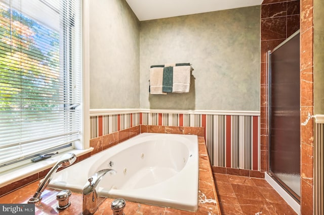 full bathroom featuring a jetted tub and a shower stall