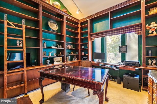 carpeted office featuring track lighting and vaulted ceiling