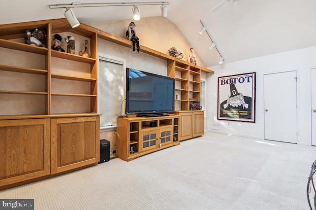 unfurnished living room featuring track lighting, light colored carpet, and vaulted ceiling