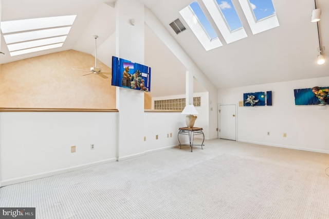 bonus room with carpet flooring, vaulted ceiling with skylight, visible vents, baseboards, and a ceiling fan
