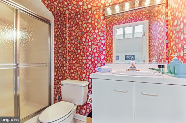 full bath featuring vanity, toilet, a shower with door, and wallpapered walls