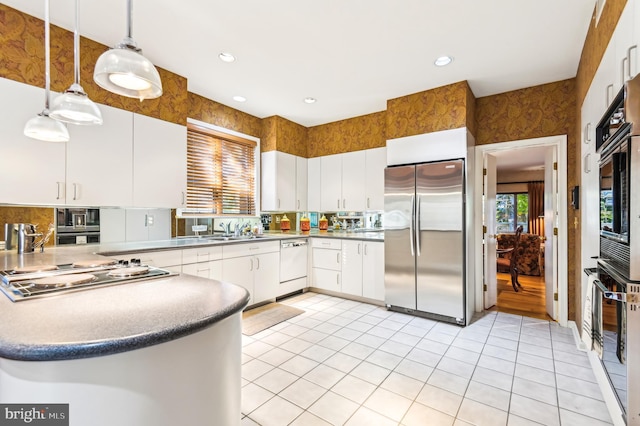 kitchen featuring recessed lighting, stainless steel appliances, light tile patterned floors, hanging light fixtures, and white cabinets