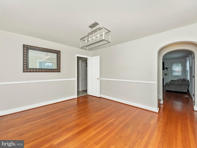 empty room featuring hardwood / wood-style floors and a notable chandelier