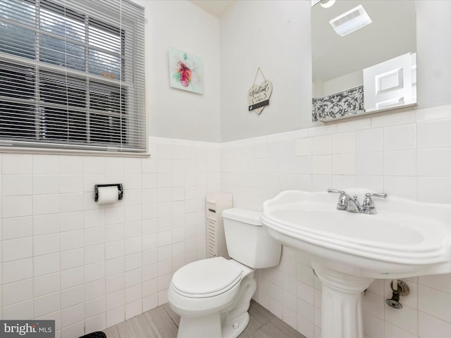 bathroom with tile walls, tile patterned flooring, and toilet