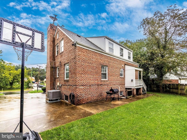 back of house featuring a yard, central AC, and a patio area