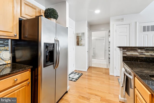 kitchen with dark stone counters, tasteful backsplash, stainless steel fridge with ice dispenser, and light hardwood / wood-style flooring